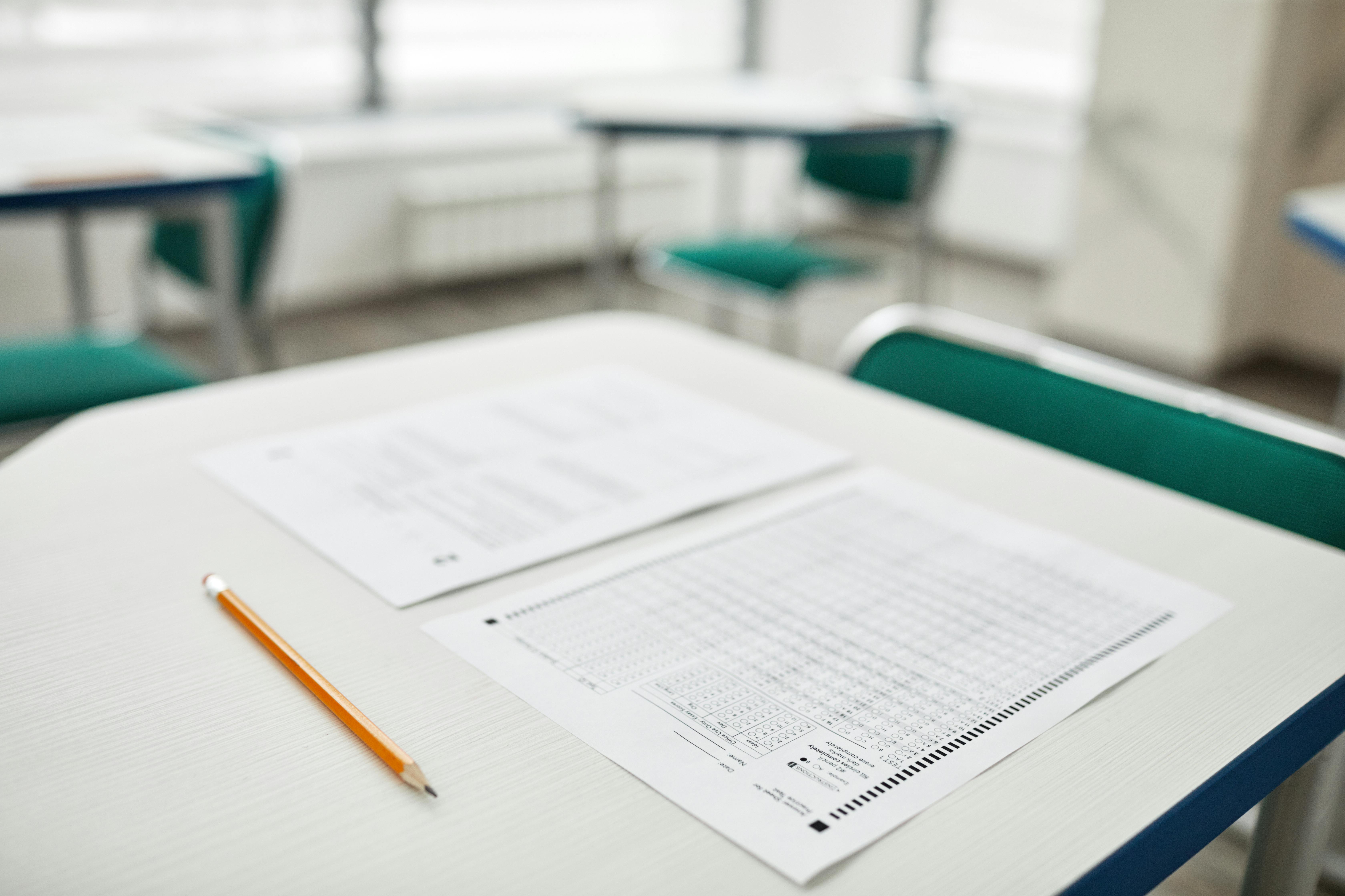 Un bureau d'école avec un examen papier dessus.